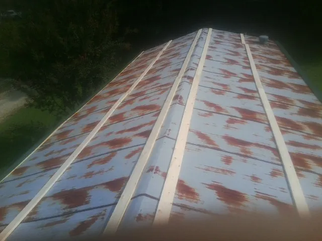 Rusted metal roof panels with new wood purlins before replacement — Storm Damage Roof Repair in Red Oak by Roofing Brothers