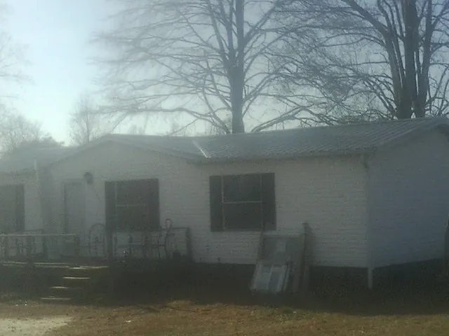 New metal roof on a white painted brick home on a foggy morning in Red Oak